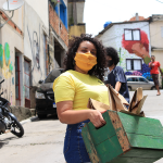 Integrante do O Corre distribui o kit de conscientização, leitura e artes na região do Grajaú, em São Paulo. Foto: divulgação/O Corre