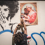 O artista Alberto Pereira cola 'Jesus Pretinho' na parede. Foto: Yago Gonçalves/Alberto Pereira