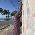 Glayson Borges aplica o lambe em frente ao mar de Alagoas. Foto: divulgação/A Coisa Ficou Preta